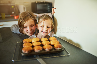 Buy stock photo Cropped shot of two young siblings looking at some freshly baked cupcakes