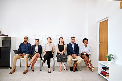 Buy stock photo Shot of a group of businesspeople seated in line while waiting to be interviewed
