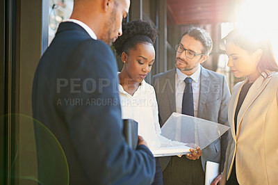 Buy stock photo Shot of a diverse group of businesspeople having a meeting on a balcony in bright sunlight