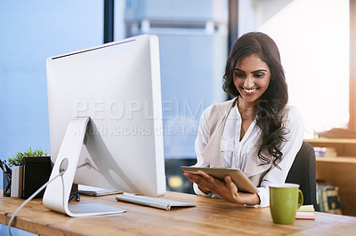 Buy stock photo Shot of a businesswoman using her digital tablet while sitting at her desk