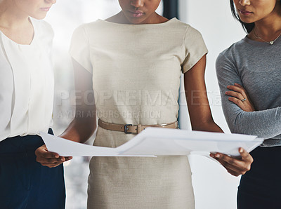 Buy stock photo Shot of a group of businesswomen analyzing paperwork together