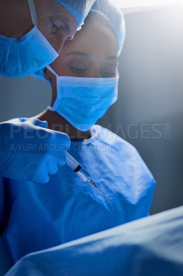 Buy stock photo Shot of group of surgeons working on a patient in an operating room