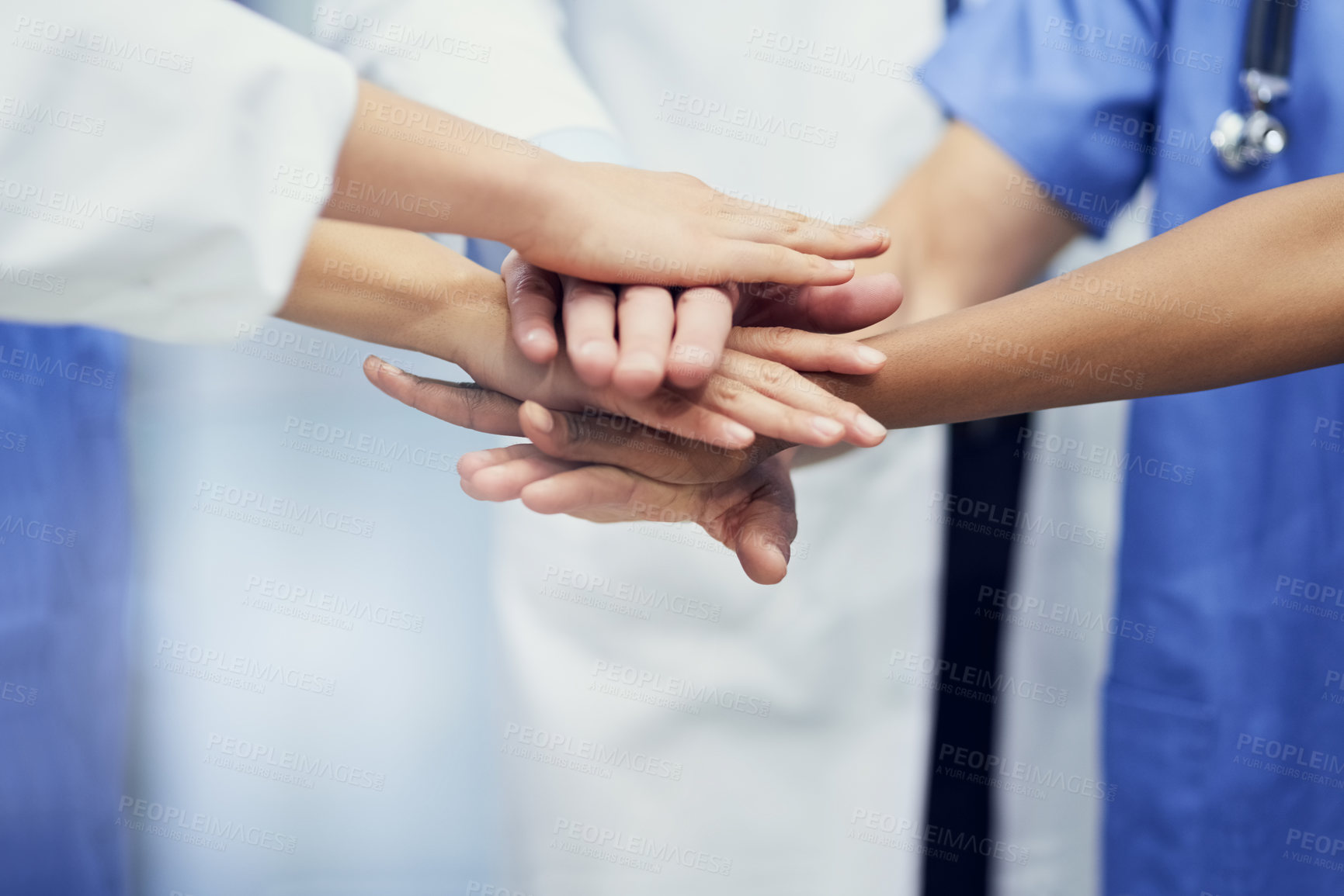 Buy stock photo Closeup shot of a group of medical professionals standing in a huddle with their hands together