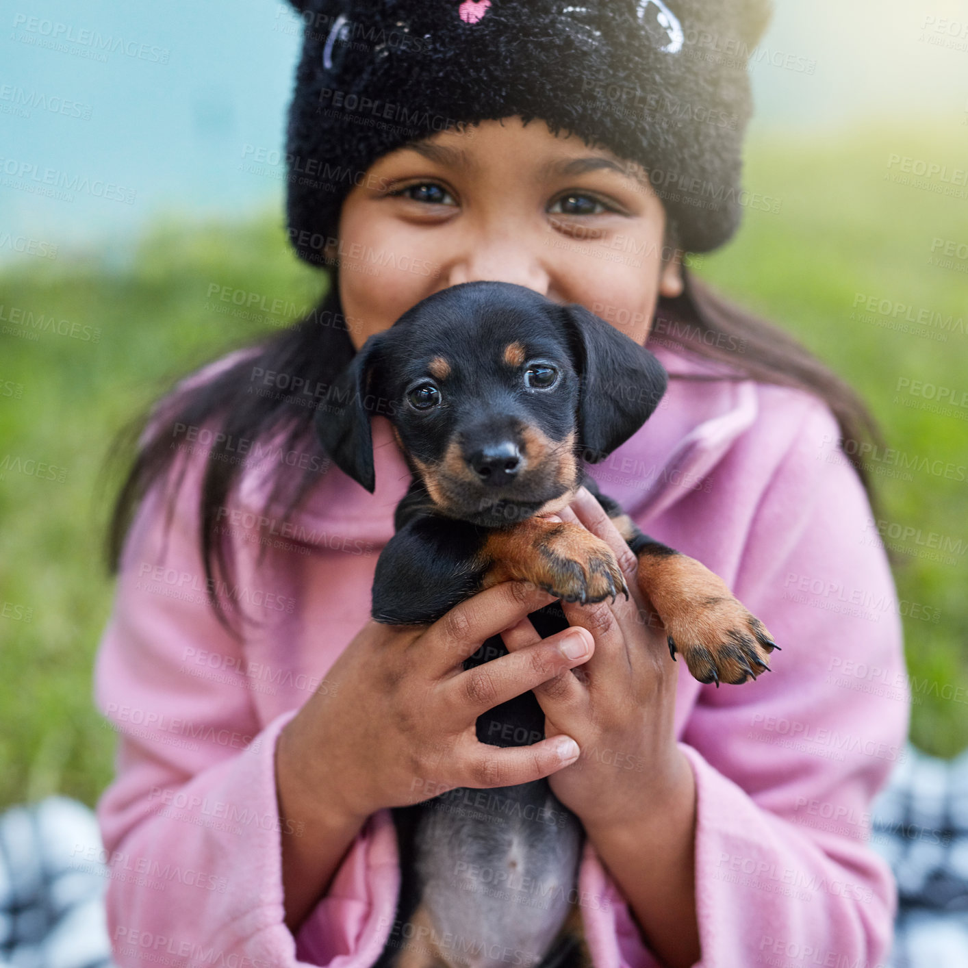 Buy stock photo Cropped portrait of a cute little girl cuddling her puppy while sitting outside