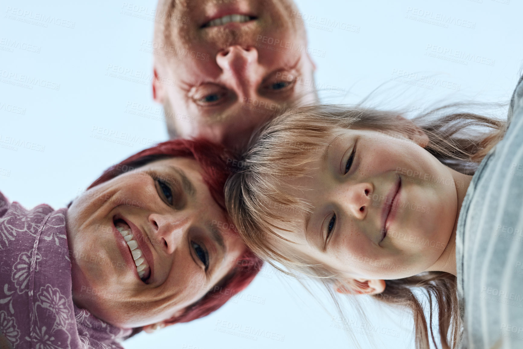 Buy stock photo Low angle portrait of a cute little girl and her parents putting their heads together