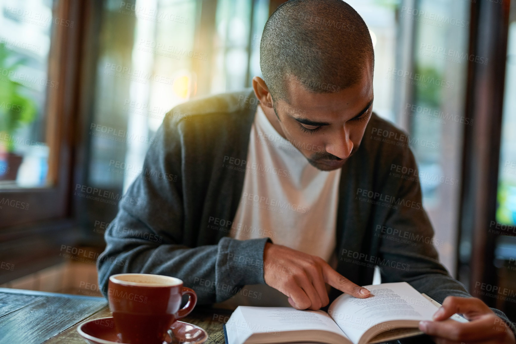 Buy stock photo Man, coffee and reading book at cafe in table with novel or story for knowledge. Restaurant, literature and break in desk to chill, relax and learning for information on day off with cup of tea