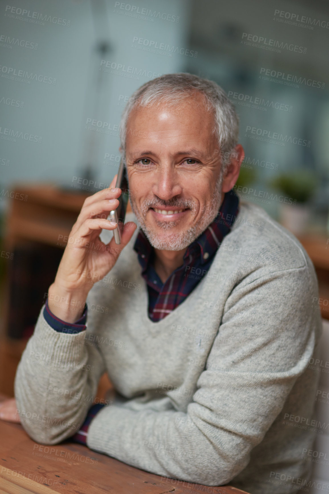 Buy stock photo Portrait of a mature businessman talking on a cellphone while working in an office