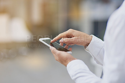 Buy stock photo Shot of an unrecognizable businessman using his cellphone