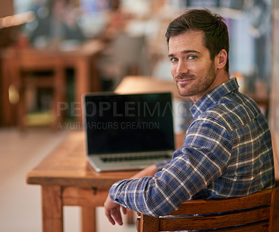 Buy stock photo Portrait of a young man using his laptop while sitting in a coffee shop