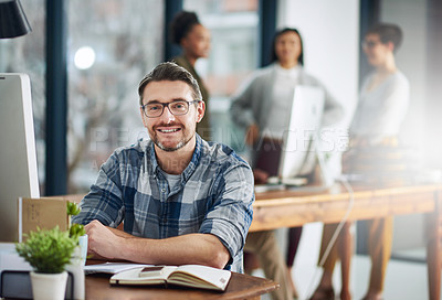 Buy stock photo Portrait of a mature businessman sitting at his desk with colleagues in the background
