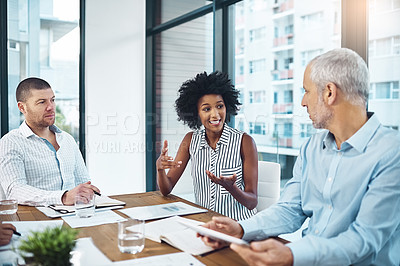Buy stock photo Shot of a group of coworkers talking together over a digital tablet in a meeting in an office
