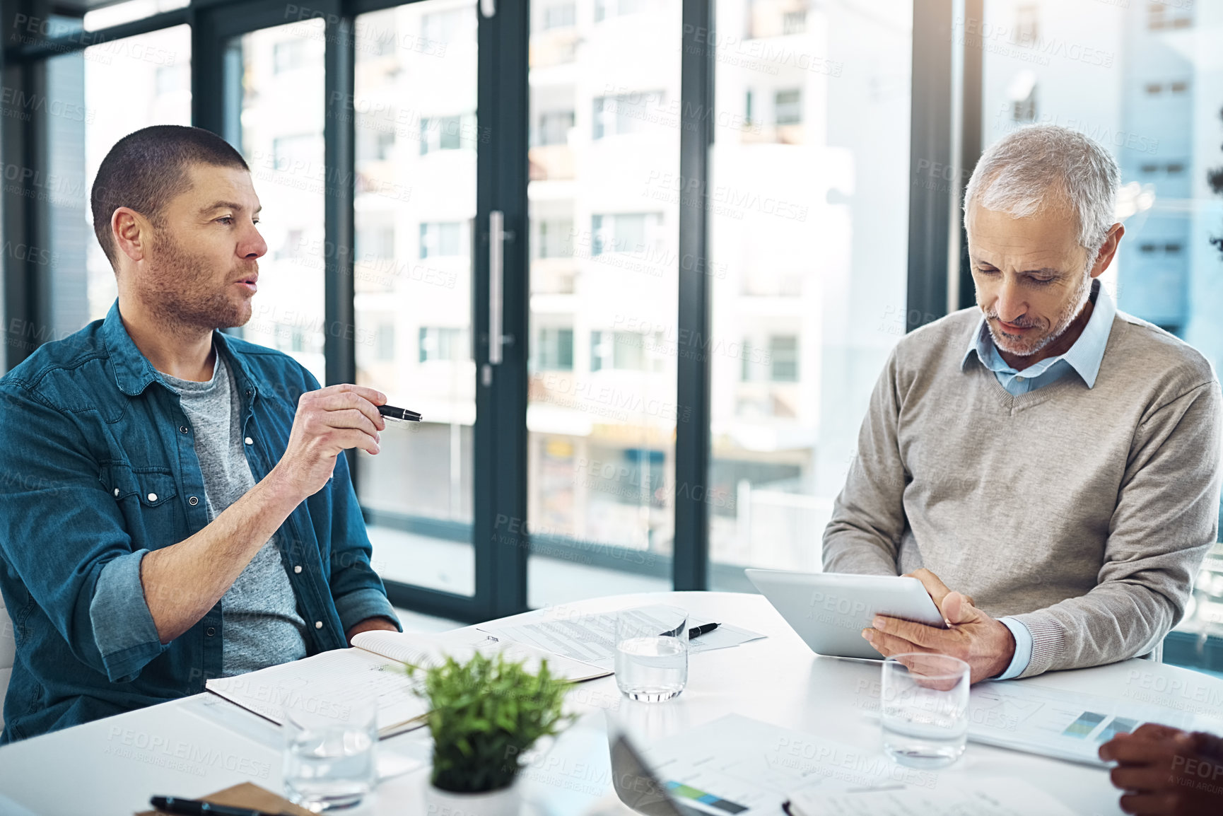 Buy stock photo Team, collaboration and ideas for company with designer, talking and pointing with tech. discussion, mature man and tablet at meeting session in boardroom office for business or startup as colleagues