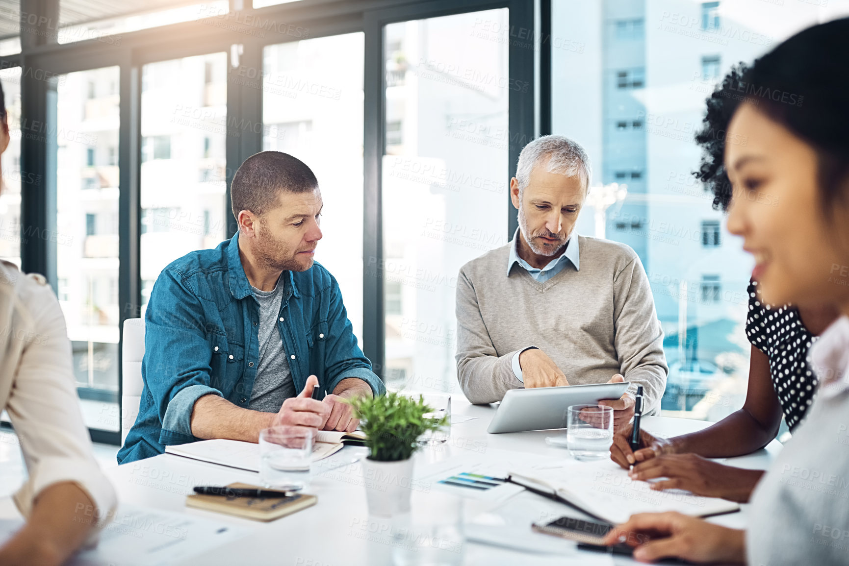 Buy stock photo Shot of a group of coworkers talking together in a meeting in an office