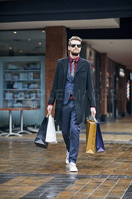 Buy stock photo Man, shopping bags and formal clothes at mall, walking and customer or shopper, discount and retail. Boutique, sale and spree in sunglasses, suit and purchase in product, deal and stylist in city