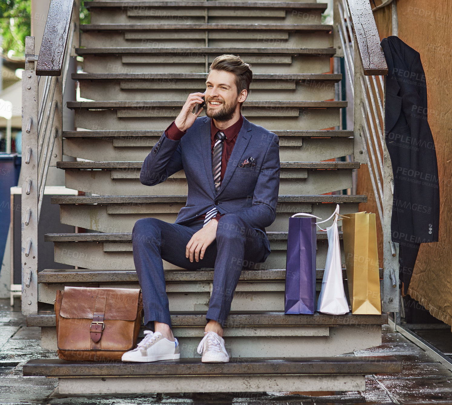 Buy stock photo Shot of a well dressed young man using his phone on a shopping spree