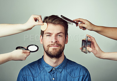 Buy stock photo Studio portrait of a young man getting a makeover against a gray background
