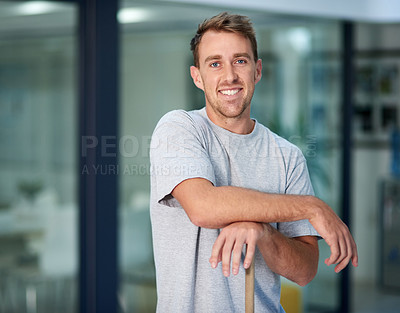 Buy stock photo Portrait of a young man leaning on a mop while cleaning the office floor