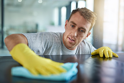 Buy stock photo Man with gloves, office cleaning service and janitor dusting dirt for health and hygiene in workplace. Professional cleaner wiping table in workspace, maintenance and disinfectant on cloth for germs.