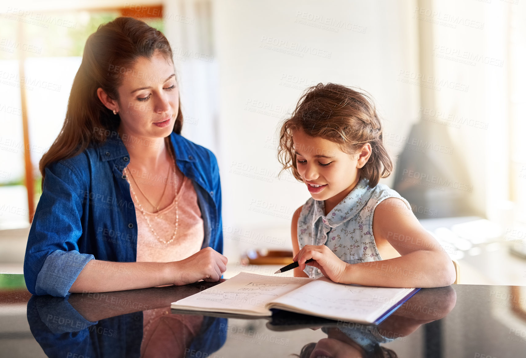 Buy stock photo Cropped shot of a mother helping her daughter with her homework