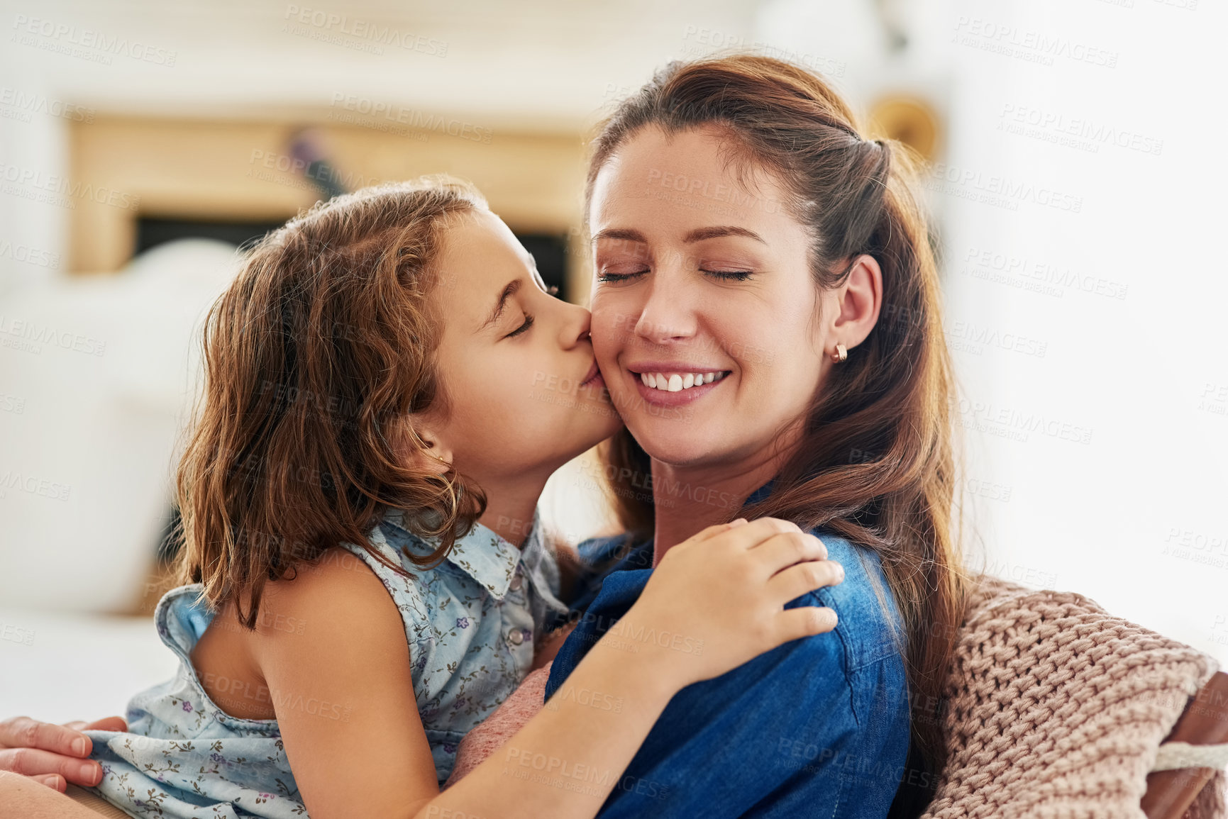 Buy stock photo Kiss, mother and girl in home for love with connection, affection and comfort with safety or security on mothers day. Mom, daughter and bonding together on sofa for support, moments and care.