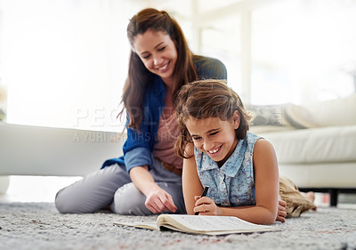 Buy stock photo Cropped shot of a mother helping her daughter with her homework