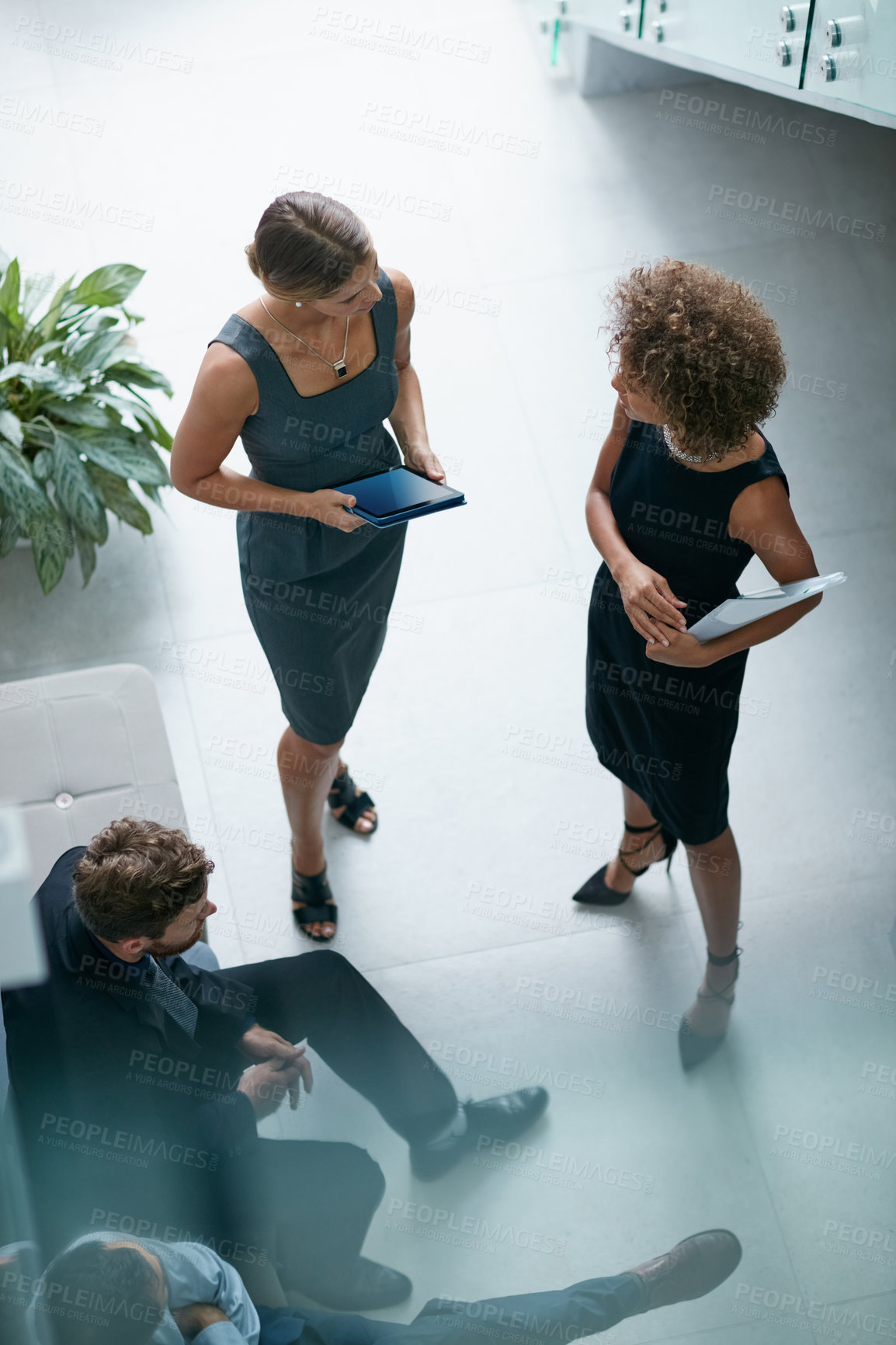 Buy stock photo High angle shot of a group of businesspeople talking together in a modern office