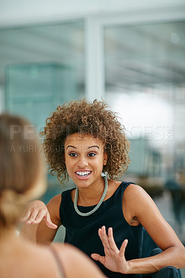 Buy stock photo Shot of two smiling coworkers talking together while sitting in a modern office