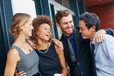 Buy stock photo Shot of a group of happy young professionals embracing each other outside