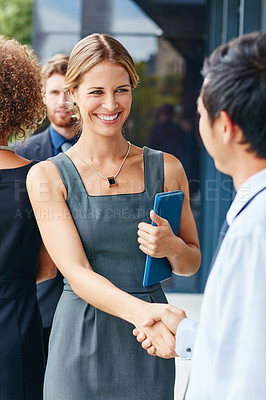 Buy stock photo Shot of a businesswoman and businessman shaking hands outdoors