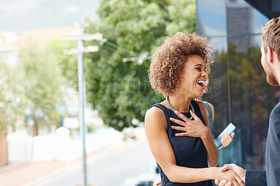 Buy stock photo Shot of a businesswoman and businessman shaking hands outdoors