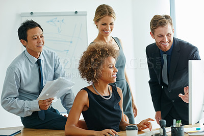 Buy stock photo Shot of a group of businesspeople discussing something on a computer