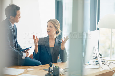 Buy stock photo Shot of two businesspeople having a discussion in an office