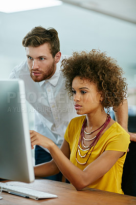 Buy stock photo Shot of a businesswoman and her male colleague looking at something on a computer screen together