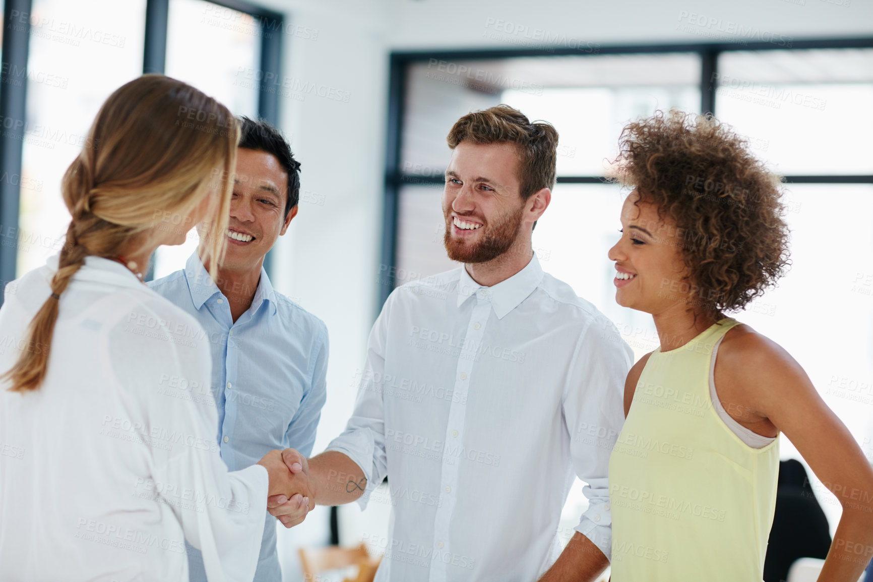 Buy stock photo Shot of a group of businesspeople congratulating their colleague on a promotion by shaking her hand