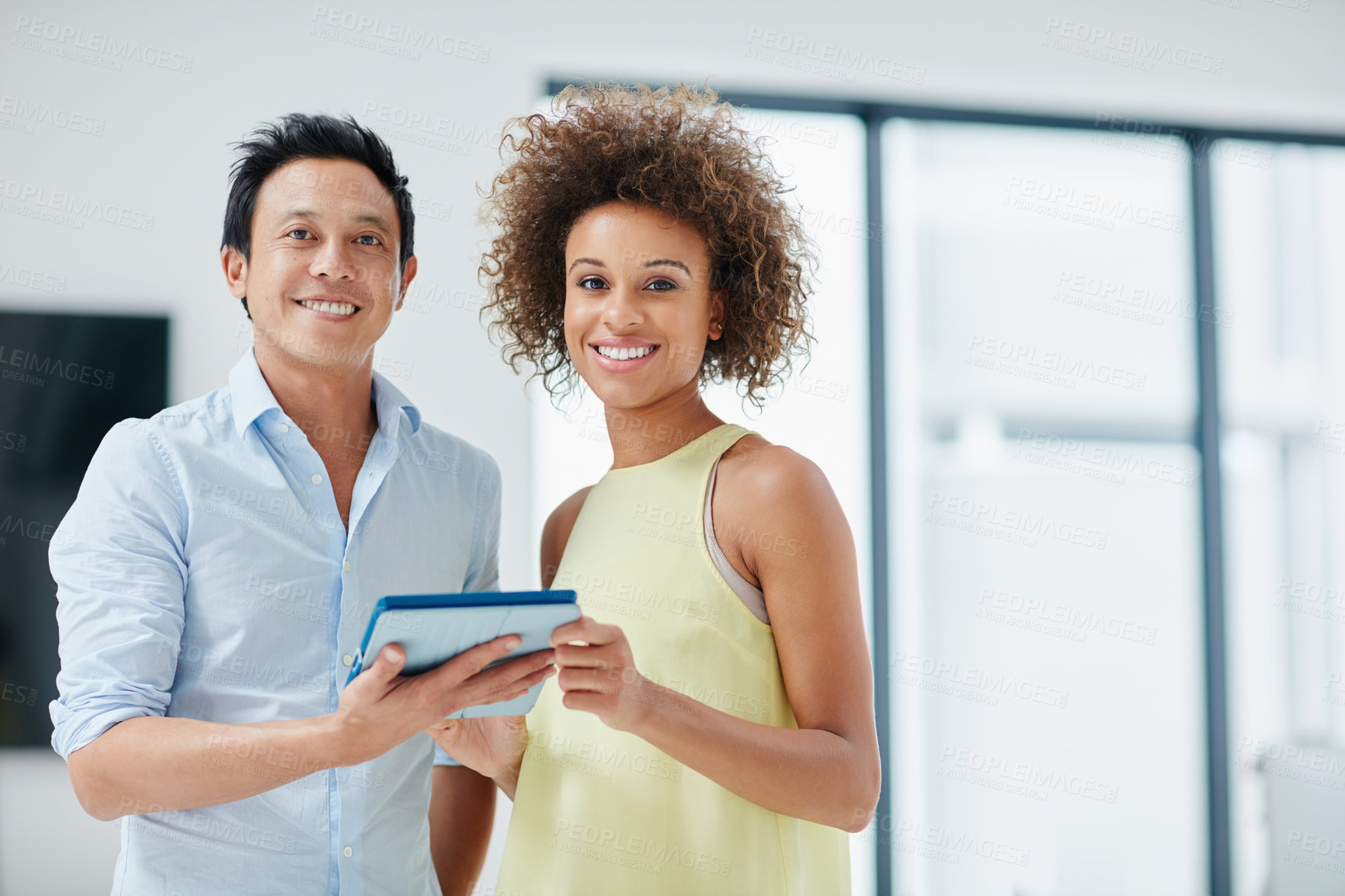 Buy stock photo Portrait of a businessman and his female colleague holding a tablet together in the office