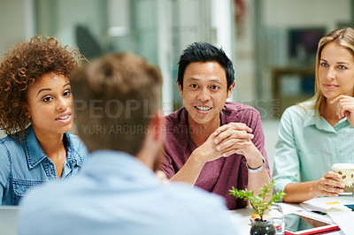 Buy stock photo Shot of a group of smiling businesspeople talking together around a table in an office