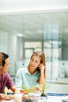 Buy stock photo Shot of two businesspeople talking together around a table in an office