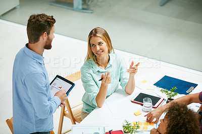 Buy stock photo High angle shot of a group of businesspeople talking together around a table in an office