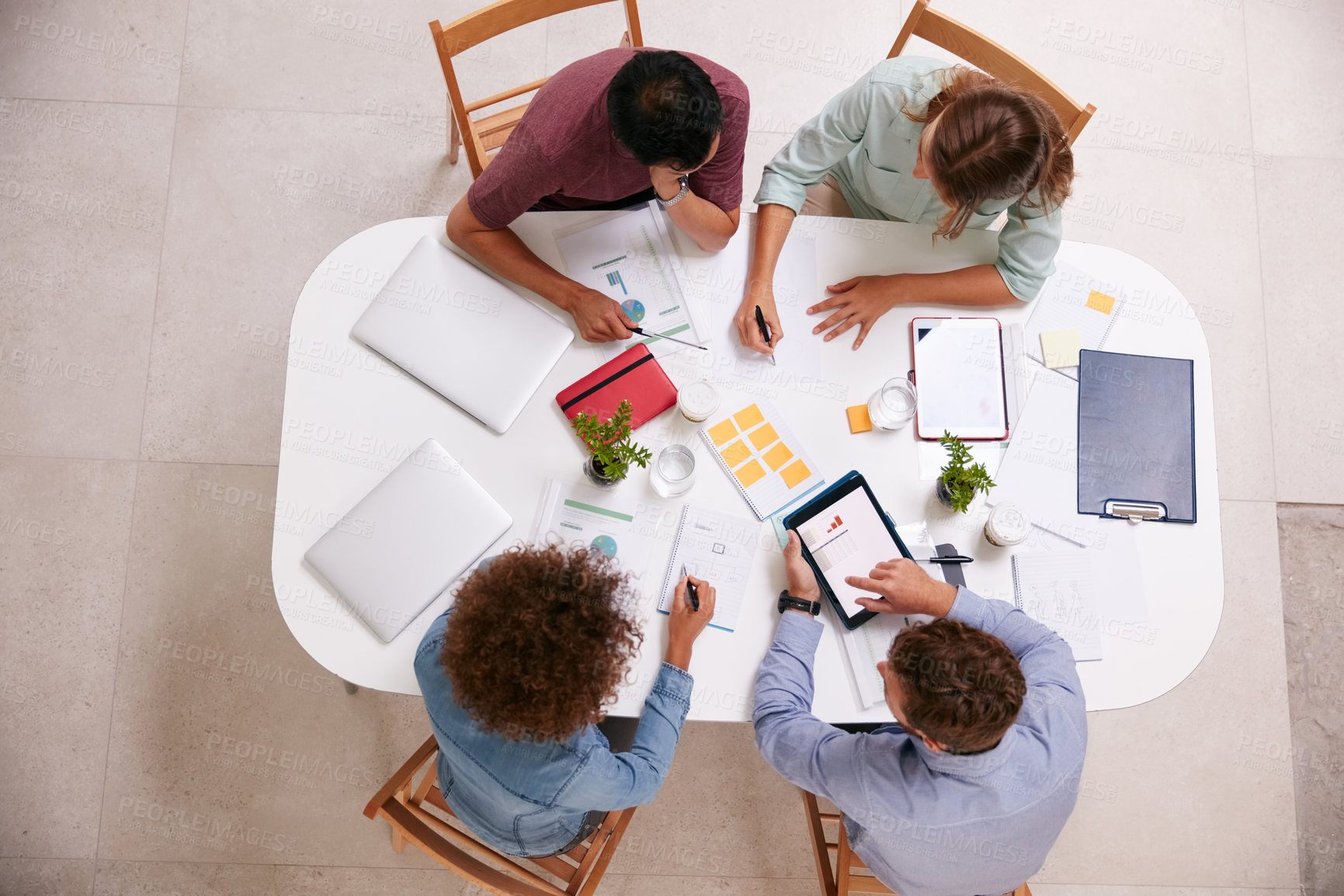 Buy stock photo High angle shot of a group of businesspeople working together around a table in an office