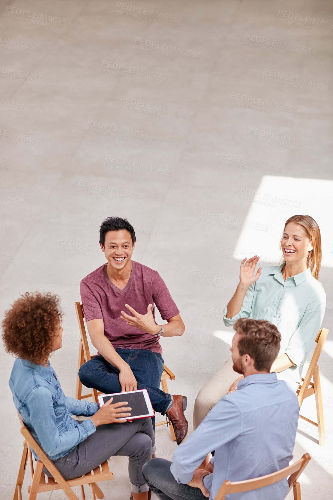 Buy stock photo High angle shot of a group of businesspeople talking together while sitting in a circle in an office