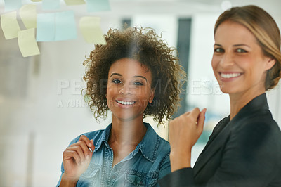Buy stock photo Shot of coworkers using sticky notes against the wall during a brainstorming session