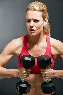 Buy stock photo Cropped portrait of an attractive young woman working out with dumbbells