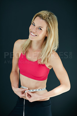 Buy stock photo Cropped portrait of an attractive young woman measuring her waist