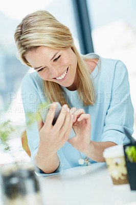 Buy stock photo Cropped shot of a young businesswoman texting on a cellphone in an office