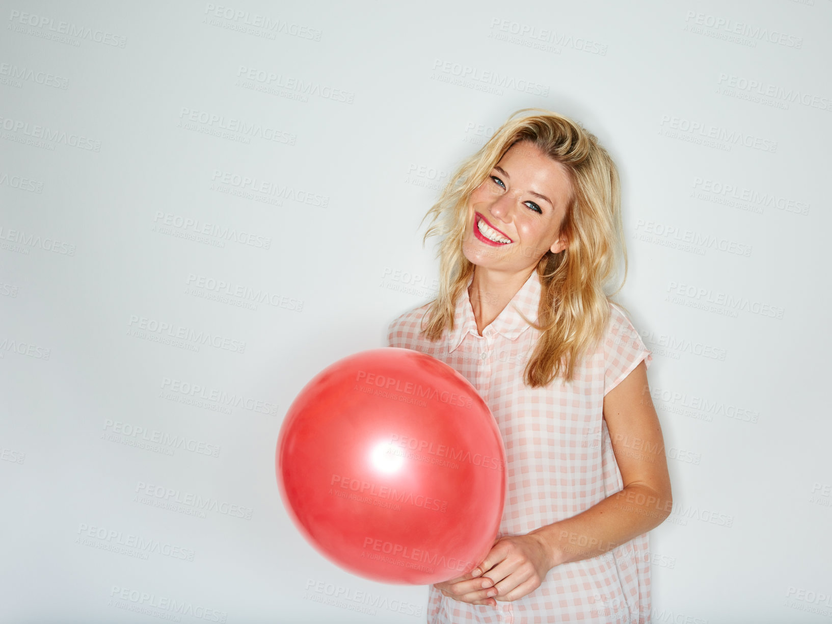 Buy stock photo Shot of a beautiful young woman holding a balloon against a white background