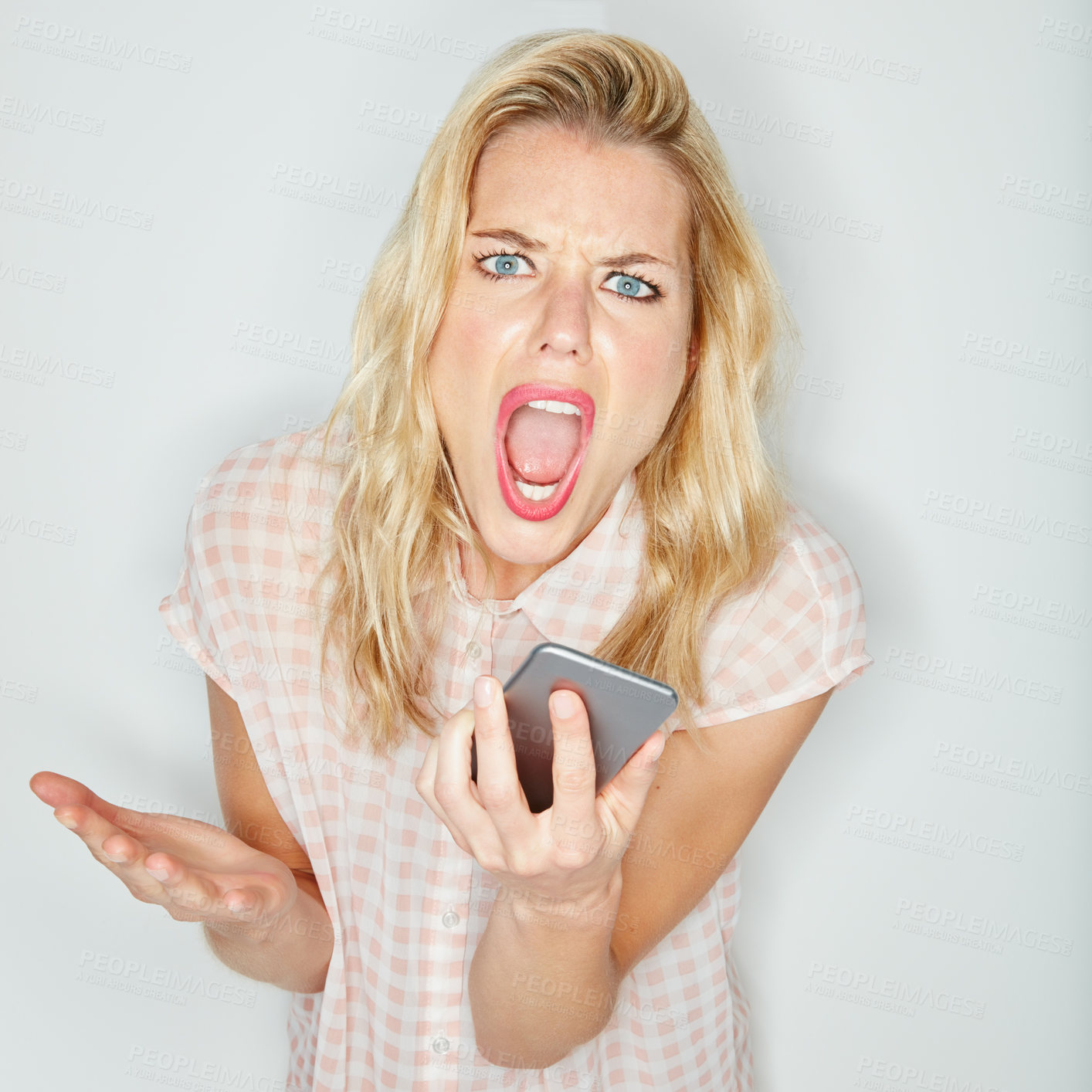 Buy stock photo Studio shot of a young woman using her cellphone