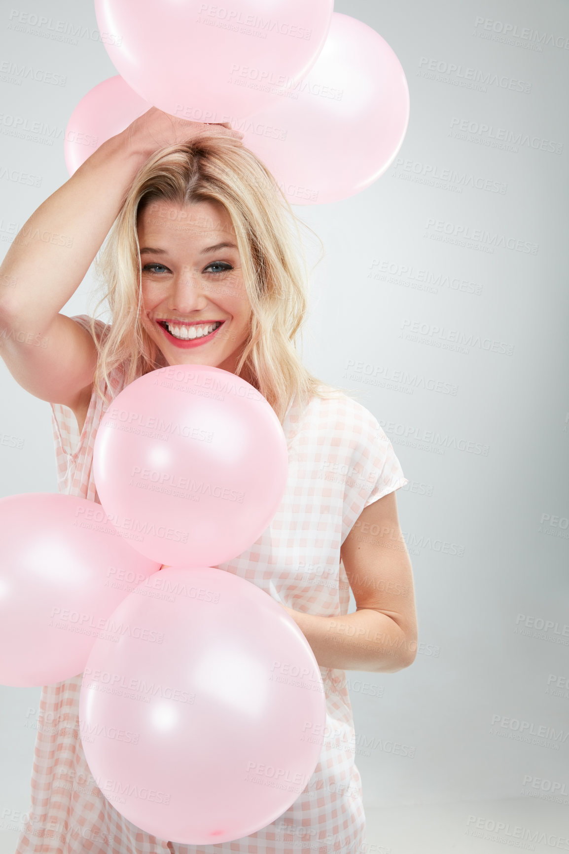 Buy stock photo Cropped shot of a beautiful young woman posing with pink balloons