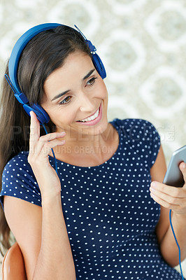 Buy stock photo Shot of an attractive young woman listening to music