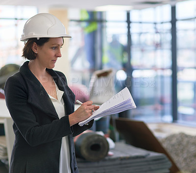 Buy stock photo Shot of a female construction manager on site wearing a hardhat