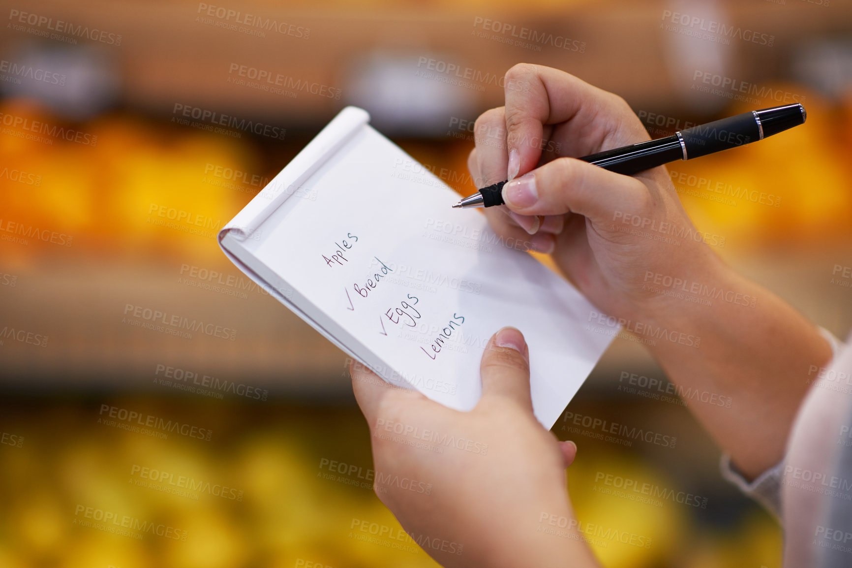 Buy stock photo Closeup shot of a woman checking her shopping list in a grocery store